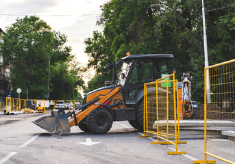Excavator on a city road. Road work, reconstruction of the underground pipe system