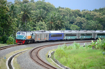 Obraz premium View of a passenger train moving in a rural or hilly area