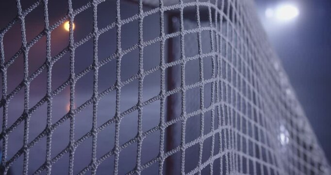 Hockey puck flies into goal net in cinematic slow motion. Close-up Goal Moment