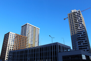 Fototapeta premium construction with cranes, construction of the new multi - storey residential building under construction. construction of new residential building