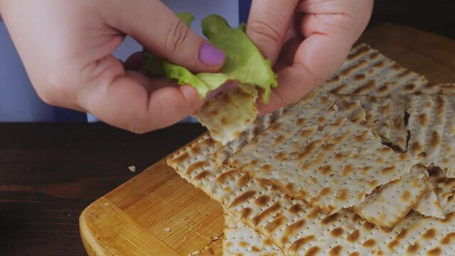 Jewish woman dips karpas in salt water during Pesach Seder meal. Medium plan.