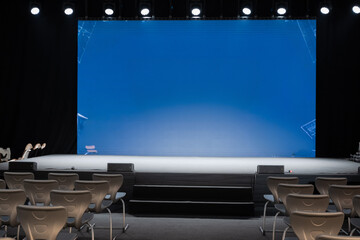 empty conference stage and a blank blue screen
