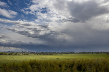 A field with a cloudy sky in the background