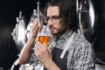 Worker sommeliers taste of craft beer on Brewery factory, brewer examining control quality and color of drink production