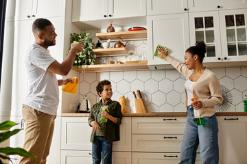 African american family happily cleaning together in the kitchen.