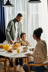 African American man woman and child happily seated at a table.