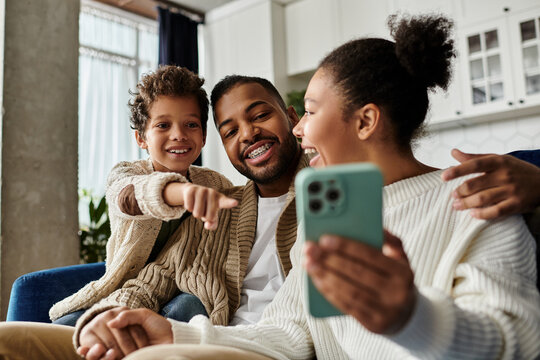 African American family joyfully taking selfie together with cell phone.