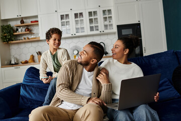 African american family engrossed in their laptop on a cozy couch.