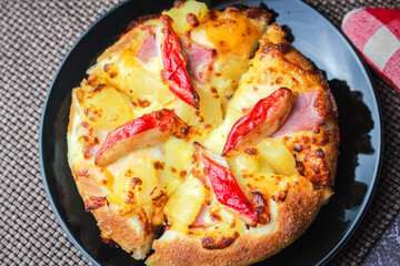 Pizza with crab sticks and cheese served on a restaurant table. With pepper and ketchup