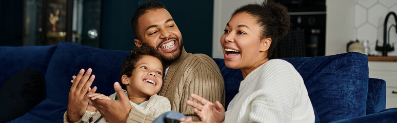 A loving African American family spending quality time together on a blue couch.