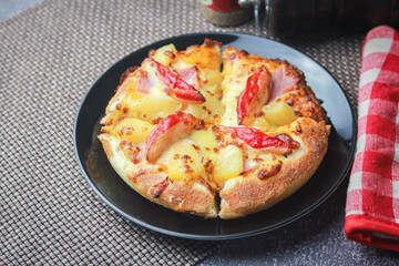 Pizza with crab sticks and cheese served on a restaurant table. With pepper and ketchup