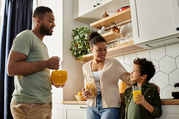 African American man, woman, child happily standing in kitchen.