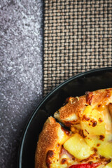 Pizza with crab sticks and cheese served on a restaurant table. With pepper and ketchup