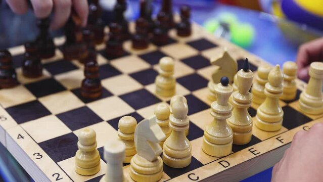 Chess tournament, kids and adults participate in chess match game in indoor hall, players of all ages play, competition in chess school club with chessboards on a table, wooden pieces on checkerboard