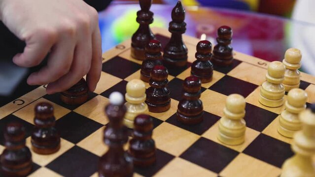 Chess tournament, kids and adults participate in chess match game in indoor hall, players of all ages play, competition in chess school club with chessboards on a table, wooden pieces on checkerboard