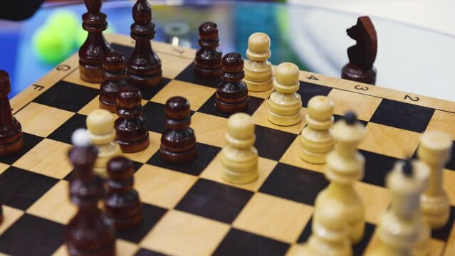 Chess tournament, kids and adults participate in chess match game in indoor hall, players of all ages play, competition in chess school club with chessboards on a table, wooden pieces on checkerboard