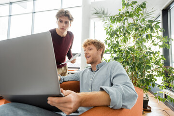 Two male students working on a laptop.