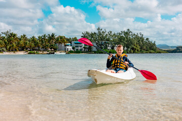 cute boy kayaks in the Indian Ocean