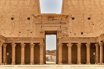 Fototapeta premium Egyptian temple with detailed carvings and columns under a clear sky.