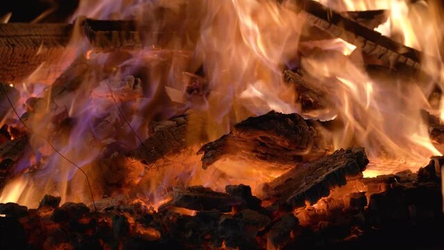 Macro shot bonfire made of logs in a brick firepit showing camping in the desert in rajasthan or the hills of shimla, manali and more with cold chilly evenings