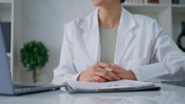 Medic explaining treatment online by laptop in clinic closeup. Woman doctor