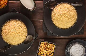 Arabic Cuisine; Top view for plain couscous bowls .Served with nuts, sugar and buttermilk. 