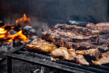 Barbeque, bbq meat cooking on grill. Traditional Asado of Argentina, Paraguay y Uruguay.