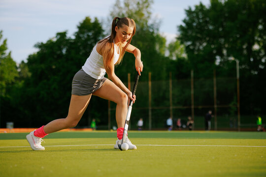 girl hockey player plays field hockey on a sunny day, the hockey player hits the ball with a stick
