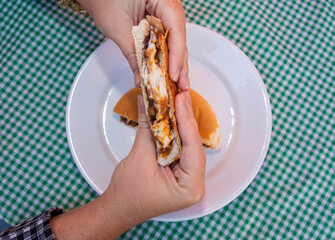 Hand holding typical Brazilian sweet burger, made with bread, cheese, white chocolate and dark...