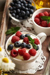 Cottage cheese blended with flax seed oil in a mug with fresh raspberries and blueberries