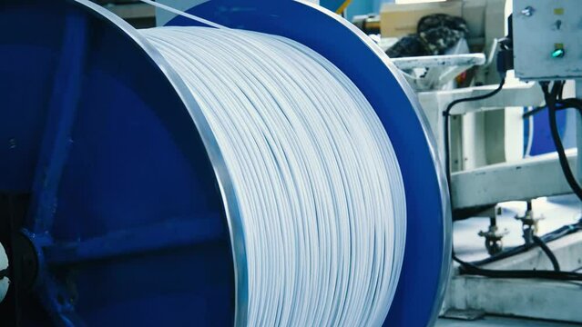 In a cable factory, the process of winding cable onto a reel is being carried out