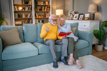 Obraz premium Senior couple man and woman husband wife looking family photos album