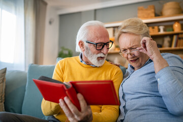 Senior couple man and woman husband wife looking family photos album