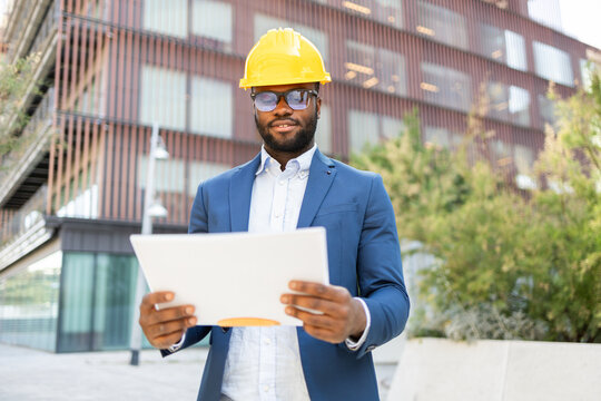 Professional African American businessman reviewing documents outdoors