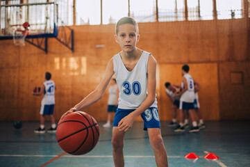 Naklejka premium Concentrated boy holding basketball