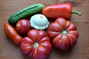 Tomatoes, squash cucumbers and peppers on a wooden background. Country natural vegetables.