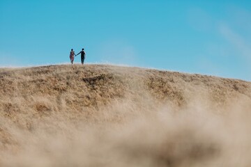 Obraz premium Man and woman doing ballet on a dry grassy ridge overlooking in the ocean in Mt Tamalpais, San Francisco, Califormia, United States of America.