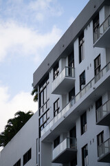 white and gray building showing balconies with palm trees in background and many architectural angles throughout the frame