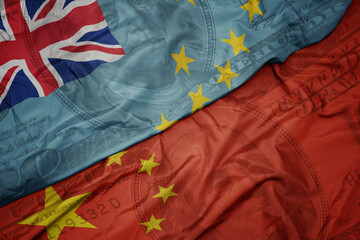 waving colorful flag of Tuvalu and national flag of china on the dollar money background. finance concept.