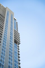 minimalistic wide shot from ground of large building with patterned windows and balconies