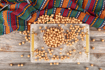 Brown soy coated chickpeas with sauce in wooden bowl, traditional Turkish coated hazelnuts.