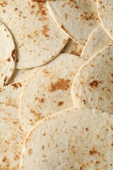 Many tasty homemade tortillas as background, top view