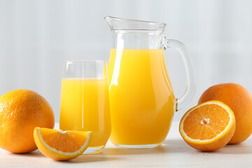 Tasty orange juice and fresh fruits on white wooden table