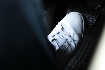 Man pushing on pedal of car brake, closeup