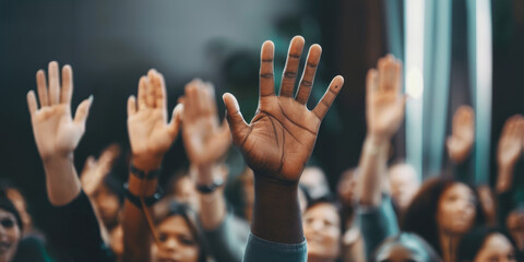 Diverse crowd raising hands during a meeting