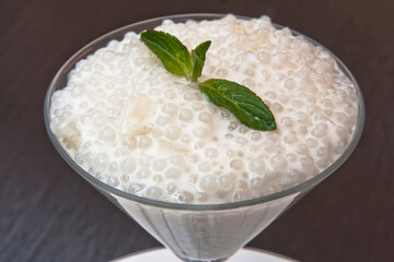 Tapioca sweet, tapioca pearl and mint dessert in a glass on a wooden table, sago seed pudding