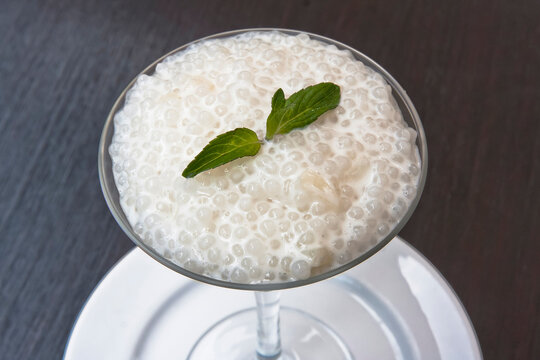 Tapioca sweet, tapioca pearl and mint dessert in a glass on a wooden table, sago seed pudding
