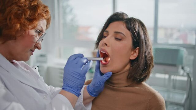 Clinic patient open mouth at health checkup closeup. Practitioner oral exam