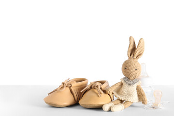 Obraz premium Stylish baby shoes with bottle of milk, pacifier and cute toy on white background
