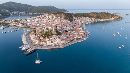 Aerial panorama of the city and harbor of Poros island in the Saronic Gulf, Greece, during a colorful summer sunset